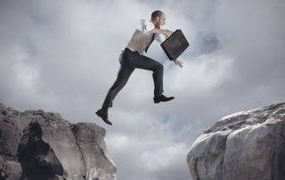 Businessman jumping over the mountains discount freight brokerage 320x202